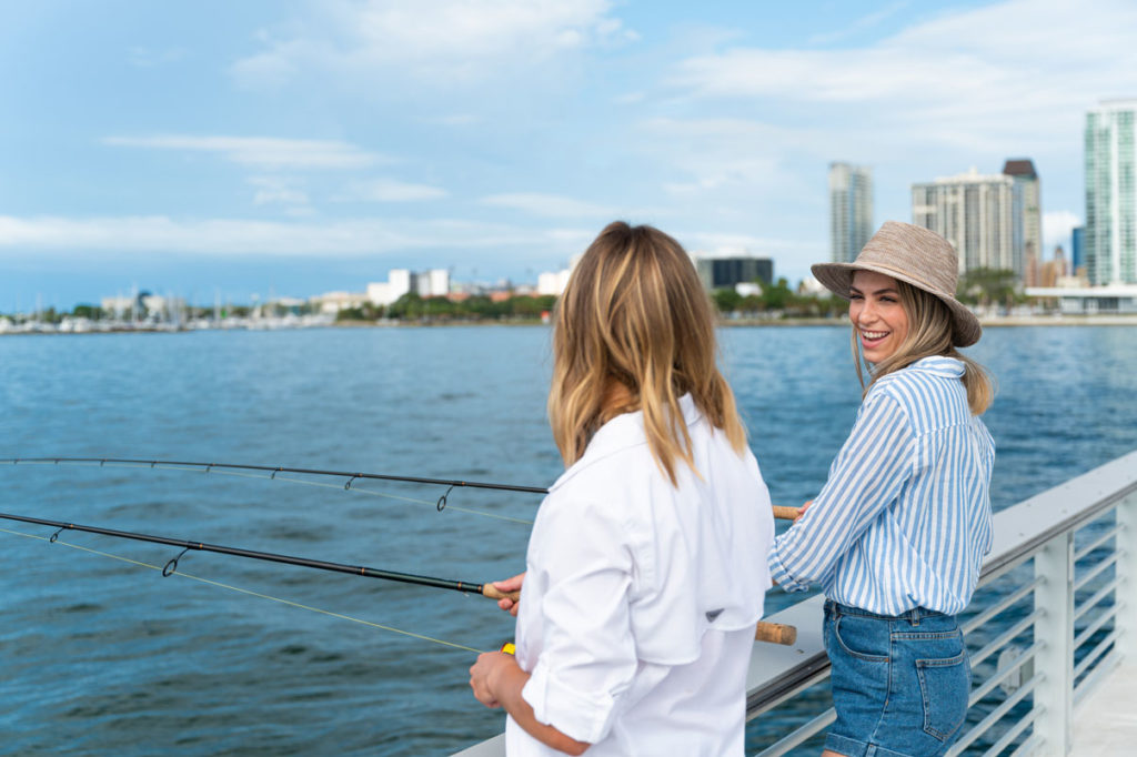 two women fishing off of pier