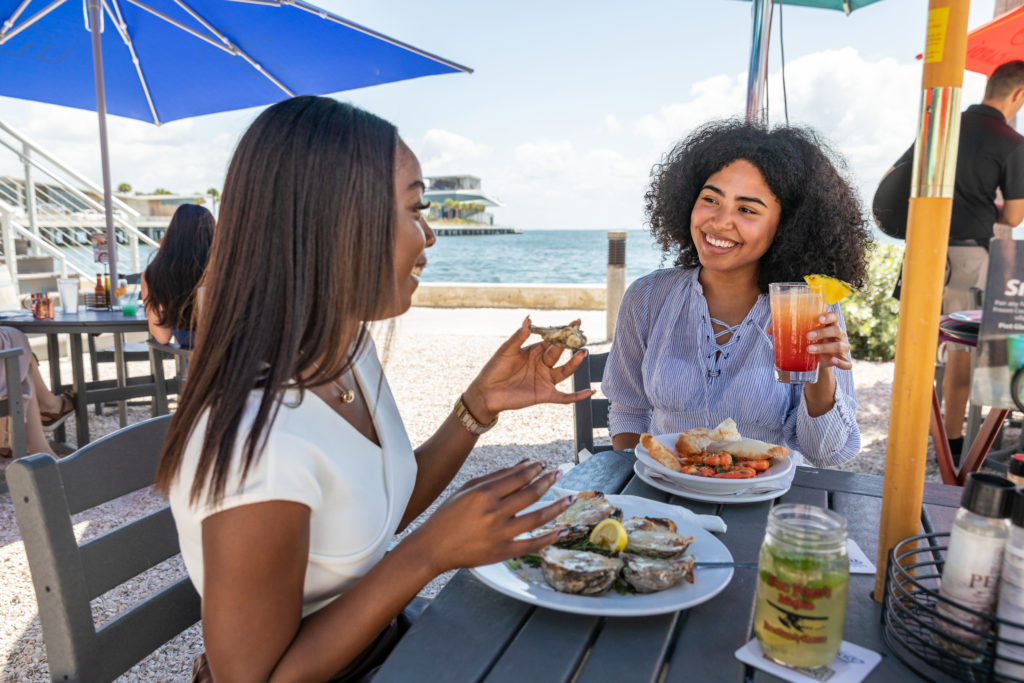 friends enjoy food and drinks on waterfront