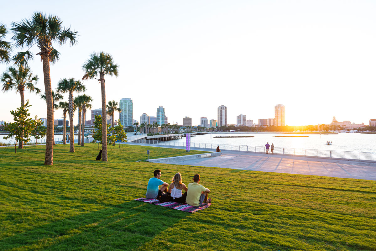 people sitting on blanket looking at st. pete skyline